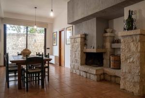 a dining room with a table and a stone fireplace at Sammit holiday home in Modica