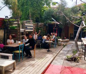 Eine Gruppe von Menschen sitzt an Tischen auf einem Deck in der Unterkunft Chania Hostel Youth 18-50 in Chania
