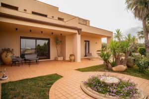 a patio of a house with a table and chairs at Sammit holiday home in Modica