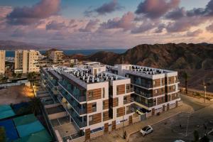 an aerial view of a building with mountains in the background at Red Canyon Spa Cozy Garden Stay by Sea N' Rent in Eilat