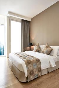 1 dormitorio con cama grande y ventana grande en THE FACE Suites, en Kuala Lumpur