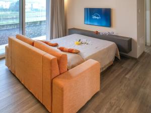 a bedroom with a bed with a couch and a tv at A Casa di Febe by Holiday World in Pisogne