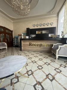 a lobby with a reception desk and a table at Reikartz Fergana in Fergana