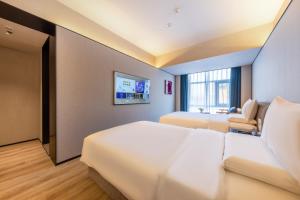 Ліжко або ліжка в номері Xi'an Big Wild Goose Pagoda Tang Dynasty Everbright City Orange Crystal Hotel