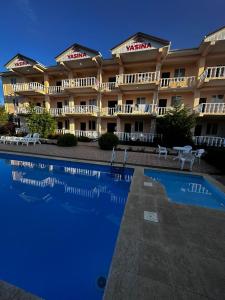 a hotel with a swimming pool in front of a building at Yasina in Bosteri