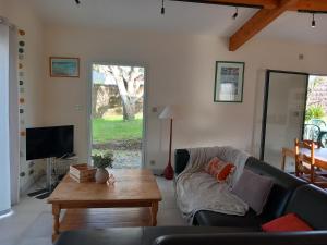 a living room with a couch and a coffee table at Maison cocon près de la mer in La Turballe