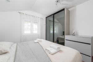 a white bedroom with a bed and a dresser at Holiday house Kristina with heated Pool, 10pax in Tugare