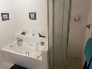 a bathroom with a bath tub with a sink at Knysna's Rest in Brenton-on-Sea