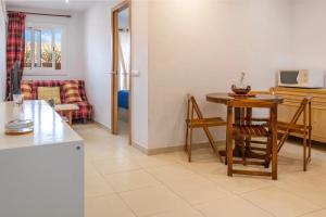 Una cocina y una sala de estar con mesa y sillas. en APARTAMENTO A 17 M. DE LA PLAYA, en Sant Antoni de Calonge
