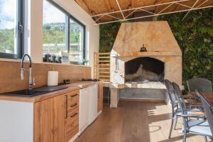 a kitchen with a stone fireplace with a table and chairs at Holiday house Kristina with heated Pool, 10pax in Tugare
