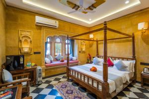 a bedroom with a canopy bed and a tv at Hotel Sky Residency With Swimming Pool in Jaisalmer +51 photos