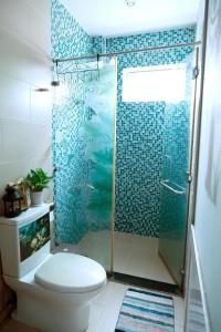 a bathroom with a toilet and a shower with blue tiles at Huong's Homestay in Ho Chi Minh City +26 photos