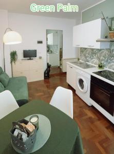 eine Küche und ein Wohnzimmer mit einem grünen Tisch in der Unterkunft Le case di Sara - Green Palm in Arma di Taggia