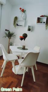 ein weißes Esszimmer mit einem weißen Tisch und Stühlen in der Unterkunft Le case di Sara - Green Palm in Arma di Taggia