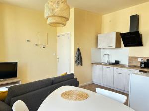 a living room with a couch and a kitchen at Appartement - 1 chambre - Centre-ville in Parthenay