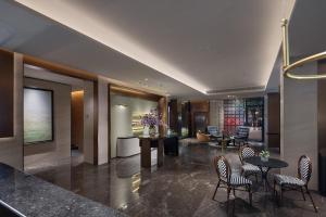 eine Lobby eines Hotels mit Stühlen und einem Tisch in der Unterkunft Baichuan Business Hotel, Haizhu District, Guangzhou in Guangzhou + 8 Fotos