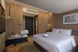 ein Schlafzimmer mit einem großen weißen Bett und einem Tisch in der Unterkunft Baichuan Business Hotel, Haizhu District, Guangzhou in Guangzhou