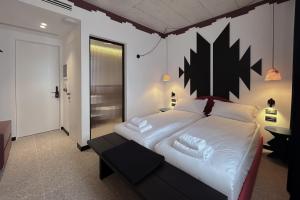 a bedroom with a large bed with white sheets and pillows at Bazaar Hotel in Tirana