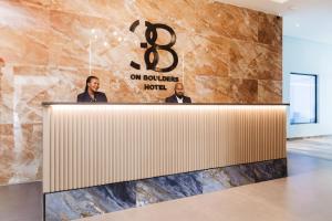 dos hombres parados en una recepción en un vestíbulo en 38 on Boulders Hotel, en Gaborone