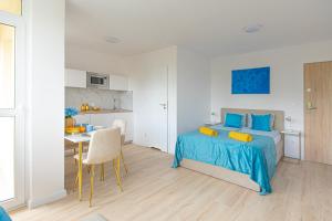 ワルシャワにあるGreen Avenue Apartments Aのベッドとテーブルとキッチンのある寝室