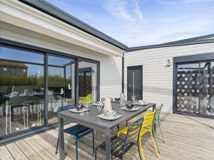 une salle à manger avec une table et des chaises sur une terrasse dans l'établissement Chalet pour 6 - Piscine chauffée - Terrasse, à Bretignolles-sur-Mer