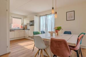 ブレスケンスにあるHello Zeeland - Vakantiehuis Zwin 112の木製のテーブルと椅子のあるキッチンとダイニングルーム