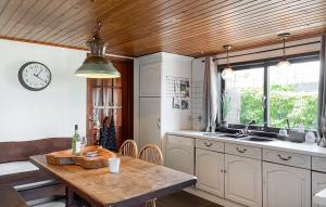 a kitchen with a table and a clock on the wall at Woonboot De Karekiet in Loosdrecht +9 photos