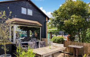 a wooden table and chairs in front of a house at Woonboot De Karekiet in Loosdrecht
