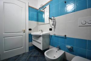 a blue and white bathroom with a sink and a toilet at Agriturismo Tenuta Kyrios con piscina in Borgagne +31 photos