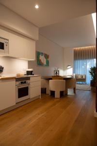 a kitchen with white cabinets and a table and a dining room at In-Town Residences in Funchal