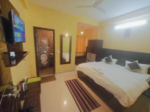 a bedroom with a bed and a flat screen tv at Ghai's Sunrise in Mussoorie