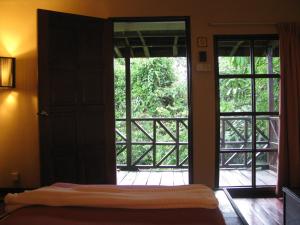 a bedroom with a door open to a balcony at The Last Frontier Boutique Resort in Bilit