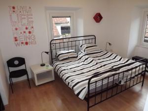 a bedroom with a bed and a chair at Velika Hiša in Rašica