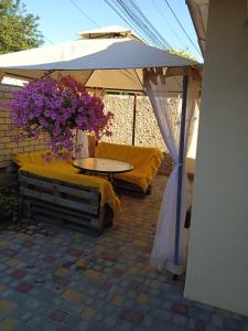 a white tent with a table and flowers on a patio at Домик у моря in Odesa