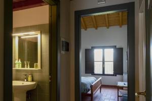 米兰Podere Ronchetto Agriturismo的带水槽、床和镜子的浴室