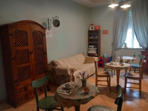 salon z kanapą, stołami i krzesłami w obiekcie ACHIRINA bed and breakfast w mieście Cisterna di Latina