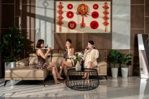 three women sitting on couches in a living room at Phúc Villa in Da Nang +34 photos