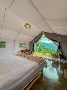 una camera con un grande letto in una tenda di HappyNest Glamping and Villa Dieng a Garung