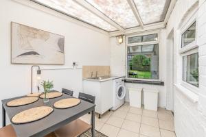 a kitchen with a table and a washing machine at Wood House by Holmesdale Homes in Kettering