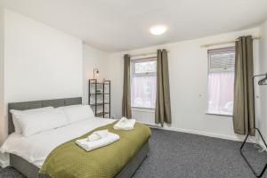 a bedroom with a bed with two towels on it at Wood House by Holmesdale Homes in Kettering