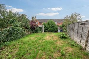 an empty yard with a fence in front of a house at Wood House by Holmesdale Homes in Kettering +37 photos