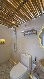e bagno con servizi igienici bianchi e doccia. di HappyNest Glamping and Villa Dieng a Garung