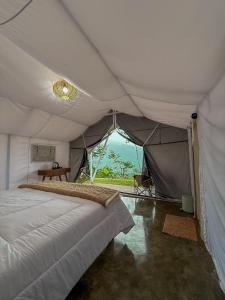 tenda con letto e tavolo di HappyNest Glamping and Villa Dieng a Garung