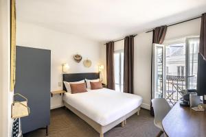 ein Hotelzimmer mit Bett und Schreibtisch in der Unterkunft Best Western Aramis Saint Germain in Paris