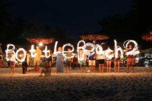a group of people standing on the beach writing the word trust at Bottle Beach 2 Bungalows in Bottle Beach