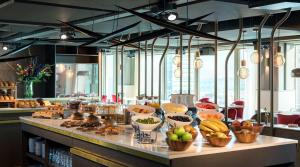 a buffet line with bowls of fruits and vegetables at NH Collection Eindhoven Centre in Eindhoven