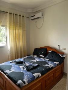 a bedroom with a large bed with a horse blanket at Appartement Jardin Dachille - Résidence Shalom Bonamoussadi avec Wifi, Clim, Parking, Gardien 24h in Douala