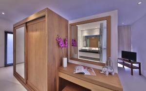 a room with a desk with a mirror and a television at Samui Blue Orchid - Adult Only in Choeng Mon Beach