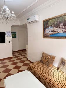 uma sala de estar com um sofá e uma pintura na parede em Tetouan Relax Apartement em Tetouan