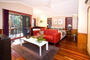 a living room with a red couch and a table at Amore On Buderim Rainforest Cabins in Buderim